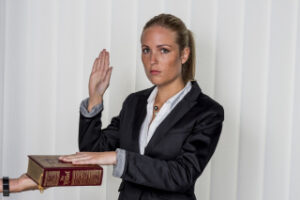 woman being sworn under oath with hand on bible